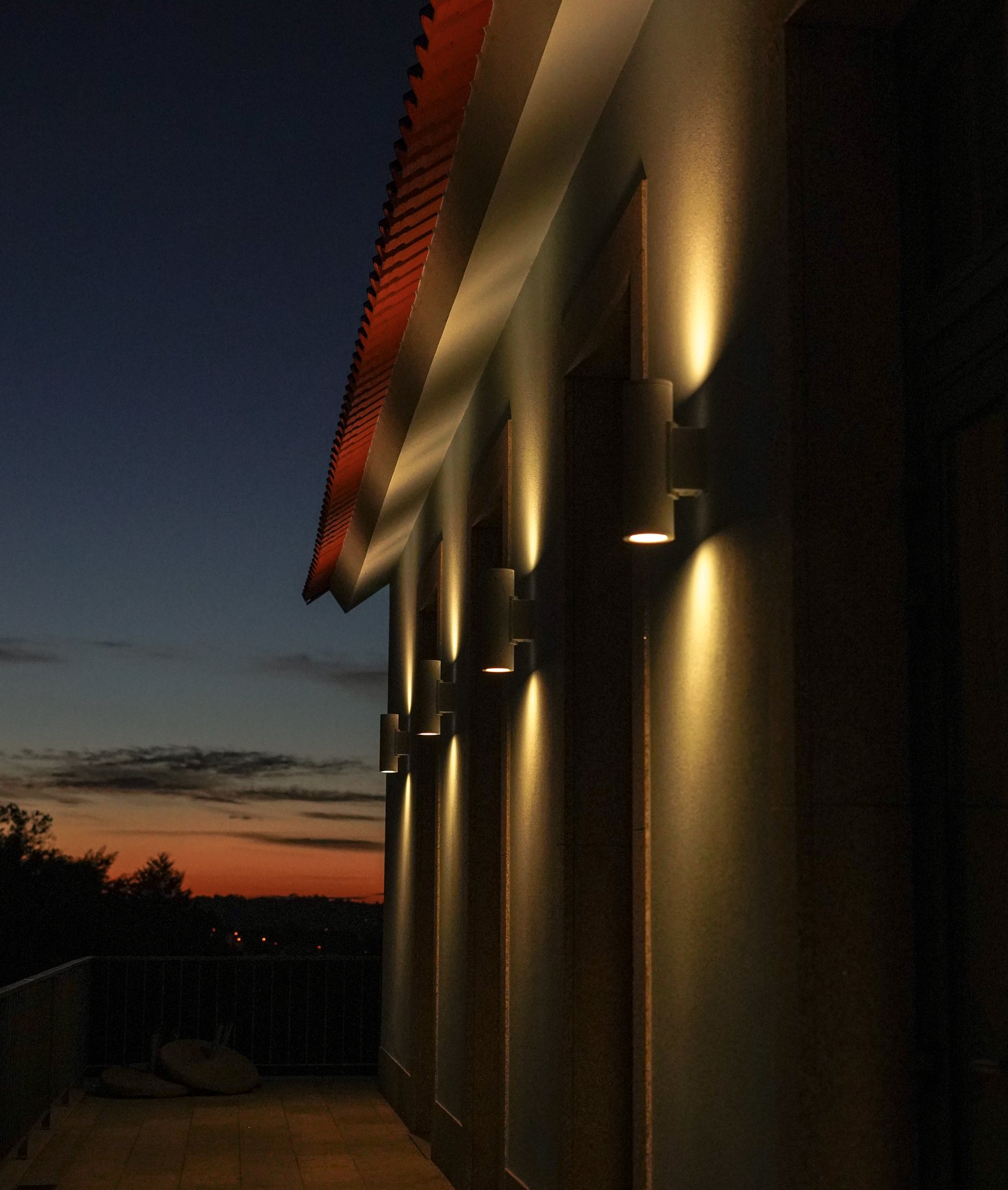 Wall lights along the terrace against the last of the sunset.